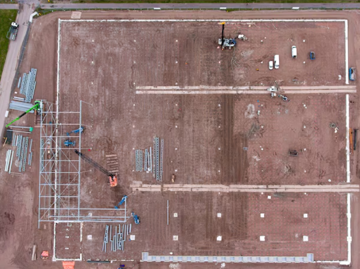 A drone flying over a construction site capturing aerial footage and a robot performing automated tasks, enhancing precision and efficiency